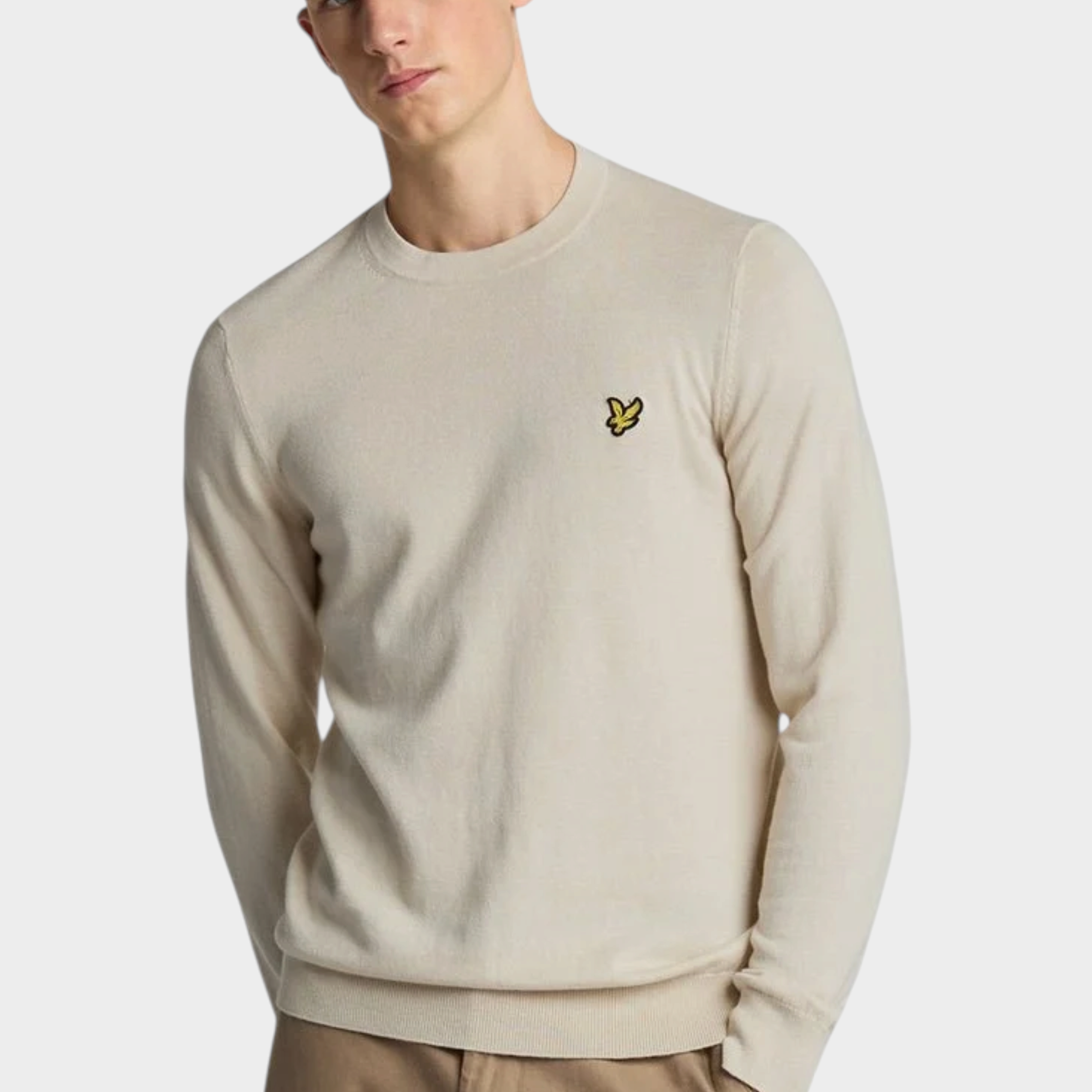 Modello indossa maglione girocollo beige in cotone e lana merino Follower SRL con logo ricamato sul petto