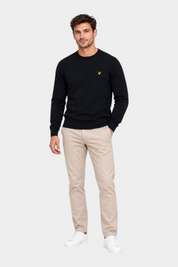 Modello indossa maglione girocollo blu navy in cotone e lana merino Follower SRL con logo dorato sul petto