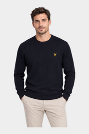 Modello indossa maglione girocollo blu navy in misto cotone e lana merino Follower SRL con logo dorato sul petto