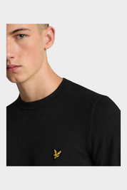 Modello indossa maglione girocollo nero in misto cotone e lana merino Follower SRL con logo aquila dorato sul petto