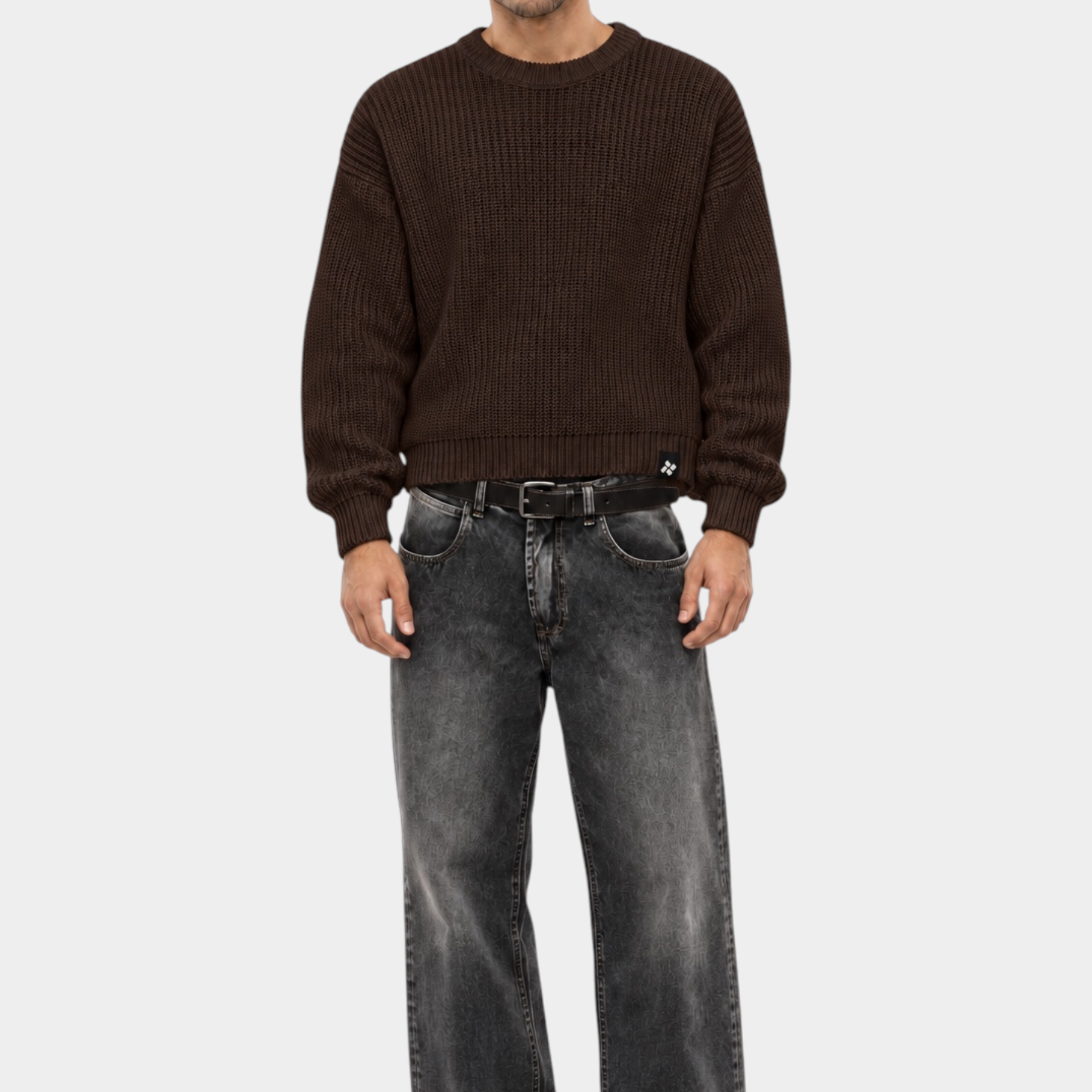 Modello indossa maglione girocollo marrone a maglia larga Follower SRL con jeans grigi e stivali neri