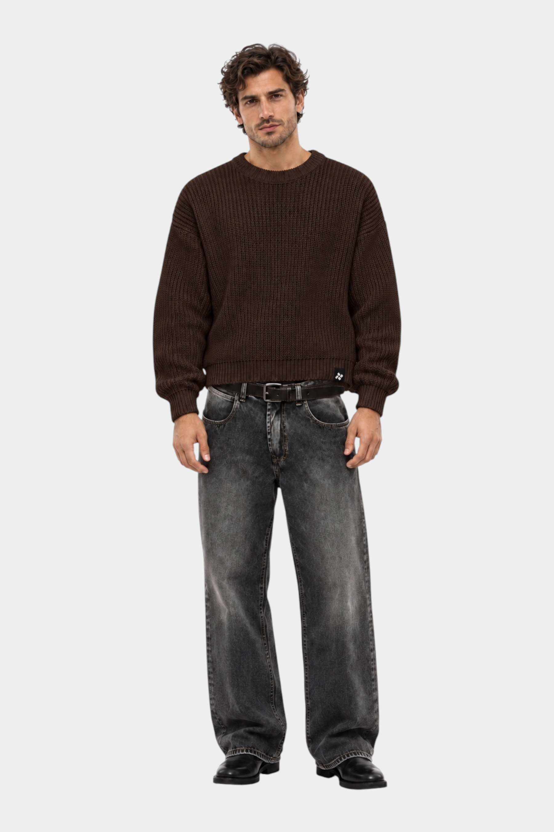 Modello indossa maglione girocollo marrone a maglia larga Follower SRL con jeans grigi e stivali neri