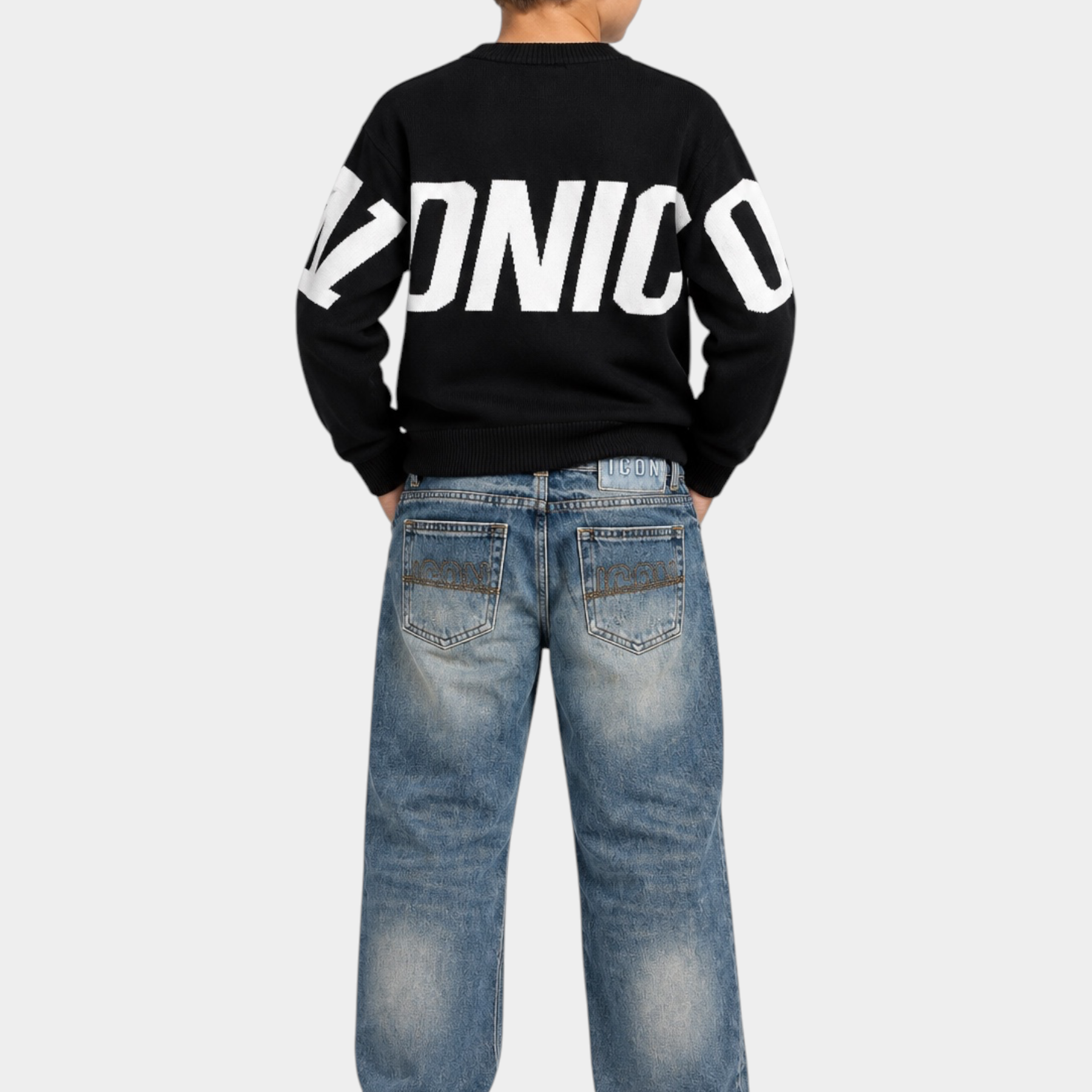 Ragazzo di spalle indossa maglione nero Follower SRL con scritta bianca ICONICO e jeans denim blu
