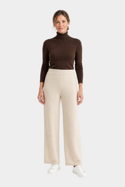 Modella indossa pantaloni ampi in NaturalSoft avorio di Follower SRL abbinati a un dolcevita marrone