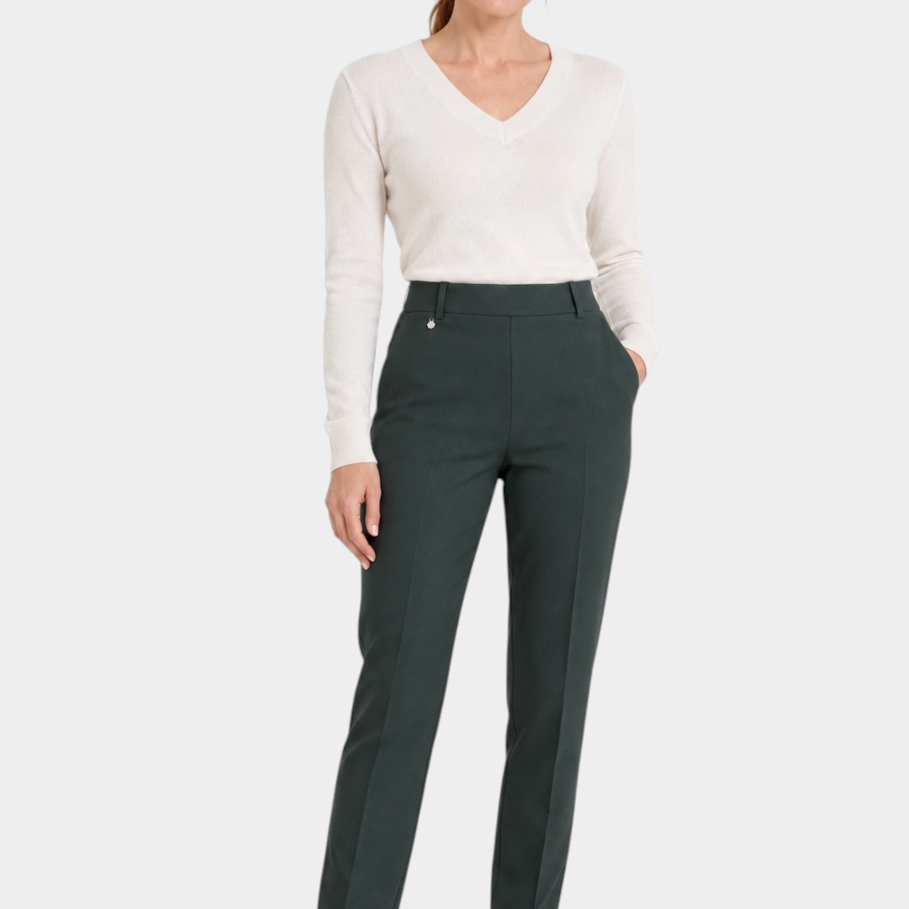 Modella indossa pantaloni dritti verdi Ragno con tasche in tessuto compact, abbinati a maglione bianco e sneakers.