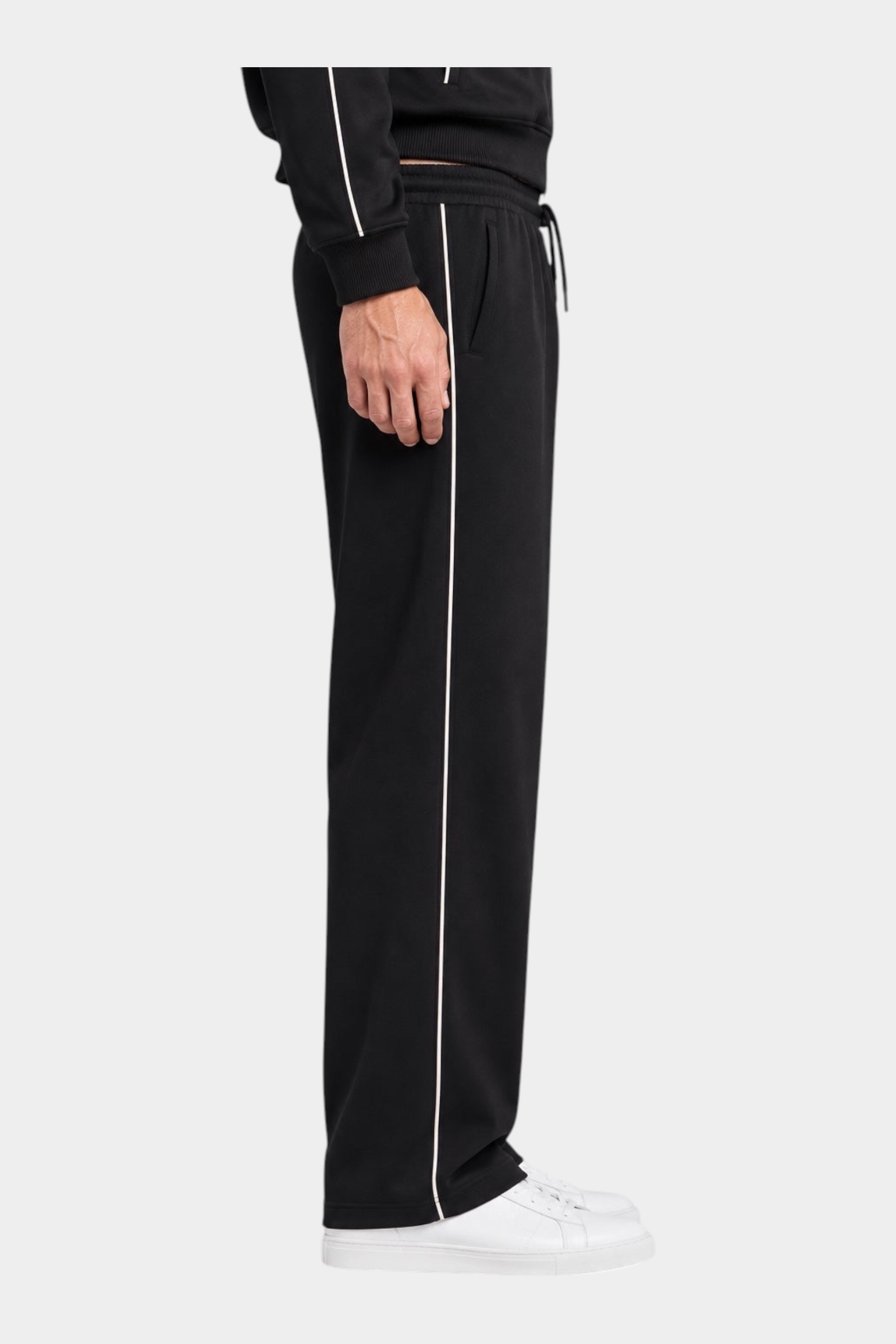 Pantalone jogger nero da uomo GUESS con riga laterale bianca, indossato con scarpe da ginnastica bianche Follower SRL