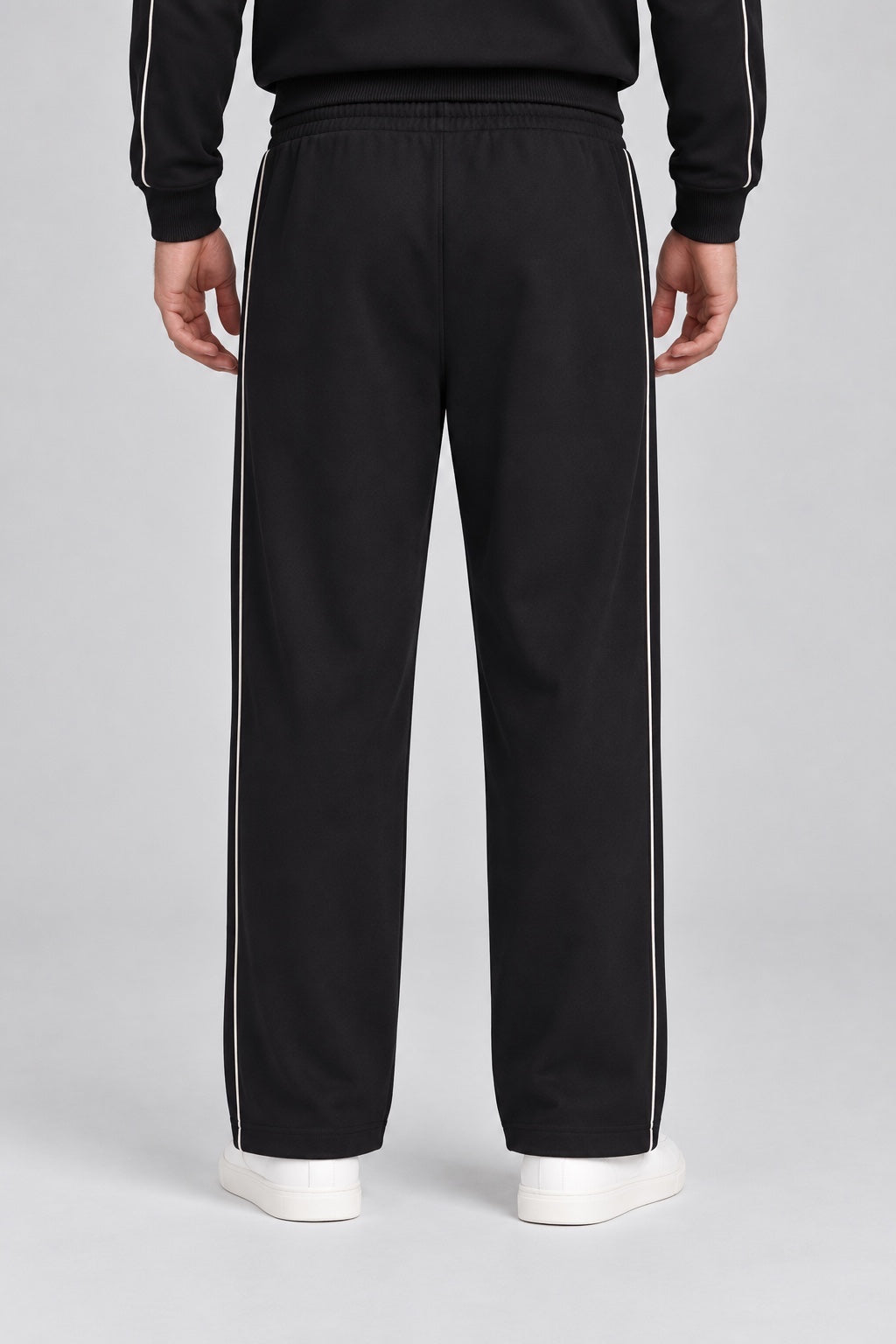 Pantalone jogger nero da uomo GUESS con bande laterali bianche a contrasto, visto da dietro su modello