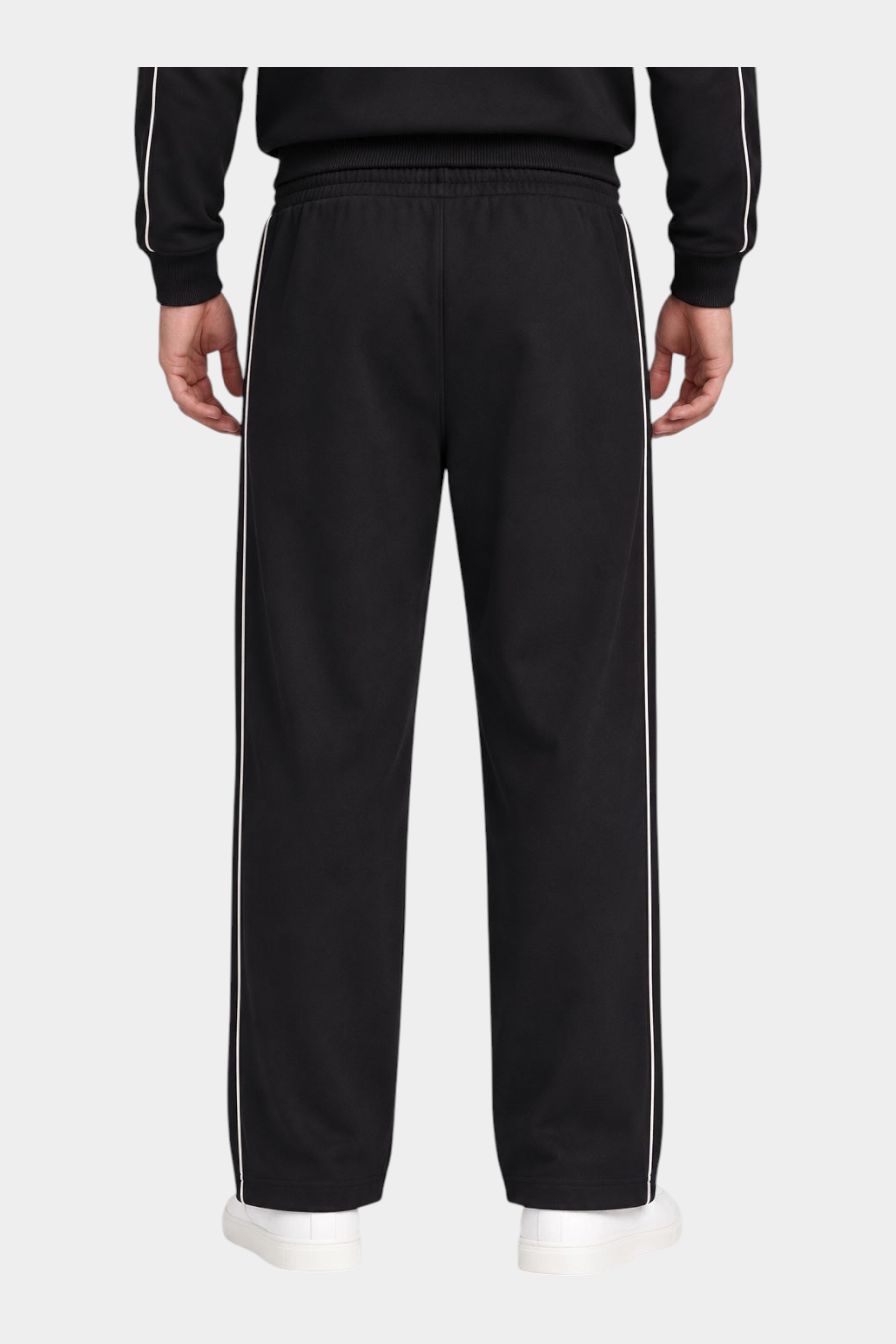 Pantalone jogger nero da uomo GUESS con bande laterali bianche a contrasto, visto da dietro su modello