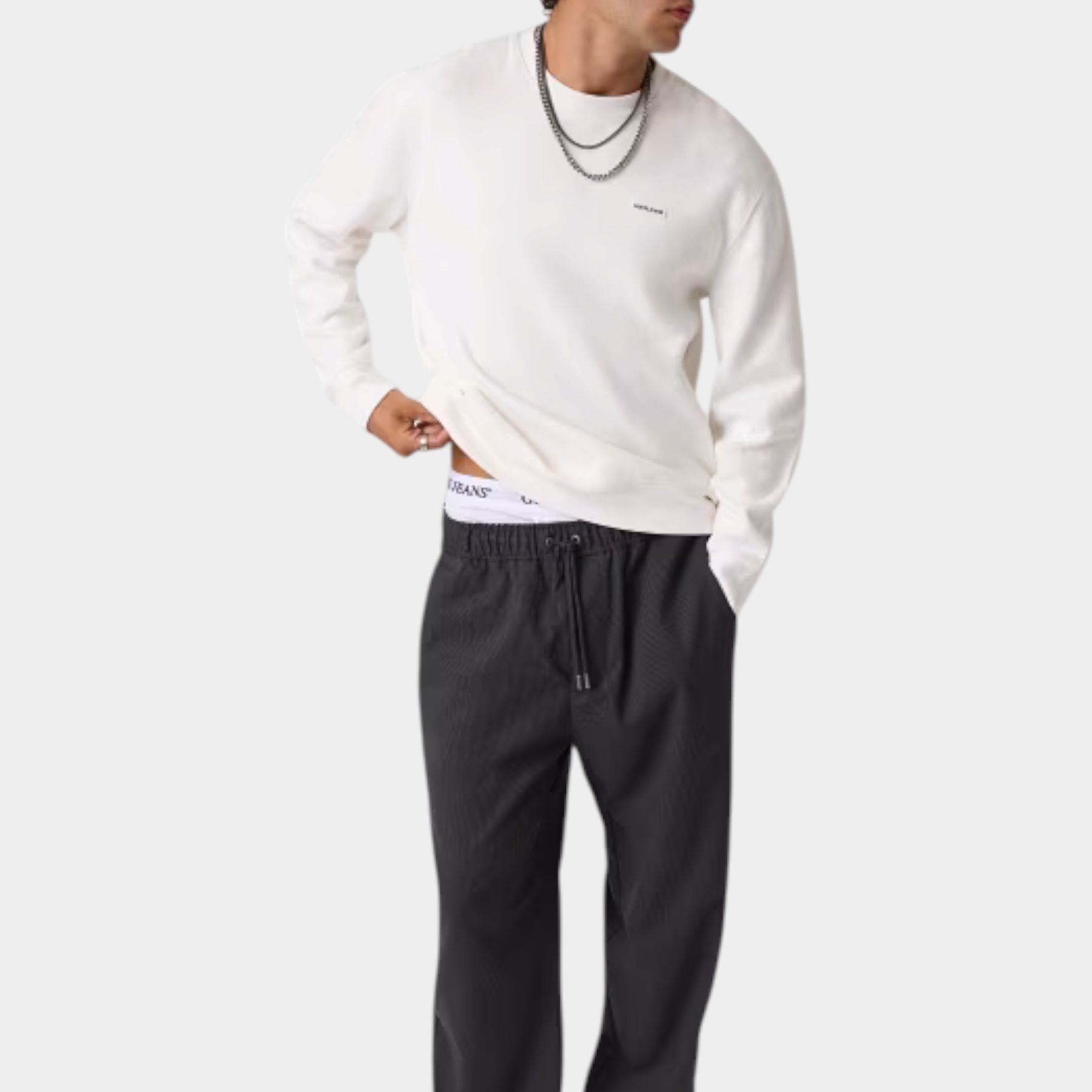 Modello indossa pantaloni a gamba larga grigi Follower SRL con vita elasticizzata e coulisse, abbinati a felpa bianca