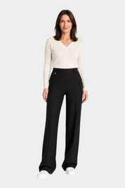 Modella indossa pantaloni a palazzo neri RAGNO con tasche e maglia beige, stile elegante Follower SRL
