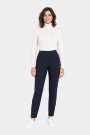 Modella indossa pantaloni a sigaretta blu Follower SRL in tessuto Compact con spacchetti e dolcevita bianco