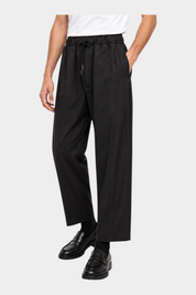 Pantaloni baggy-fit neri Follower SRL con coulisse in vita e pince, indossati da un modello con mocassini
