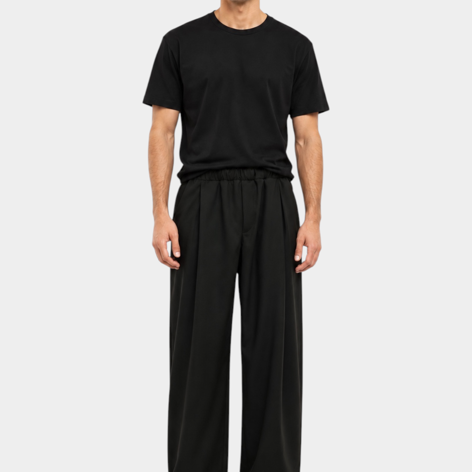 Modello indossa pantaloni baggy-fit neri con pinces di Follower SRL abbinati a una t-shirt nera