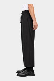 Pantaloni uomo neri Follower SRL dal taglio baggy con coulisse in vita e pince, vista laterale su sfondo bianco
