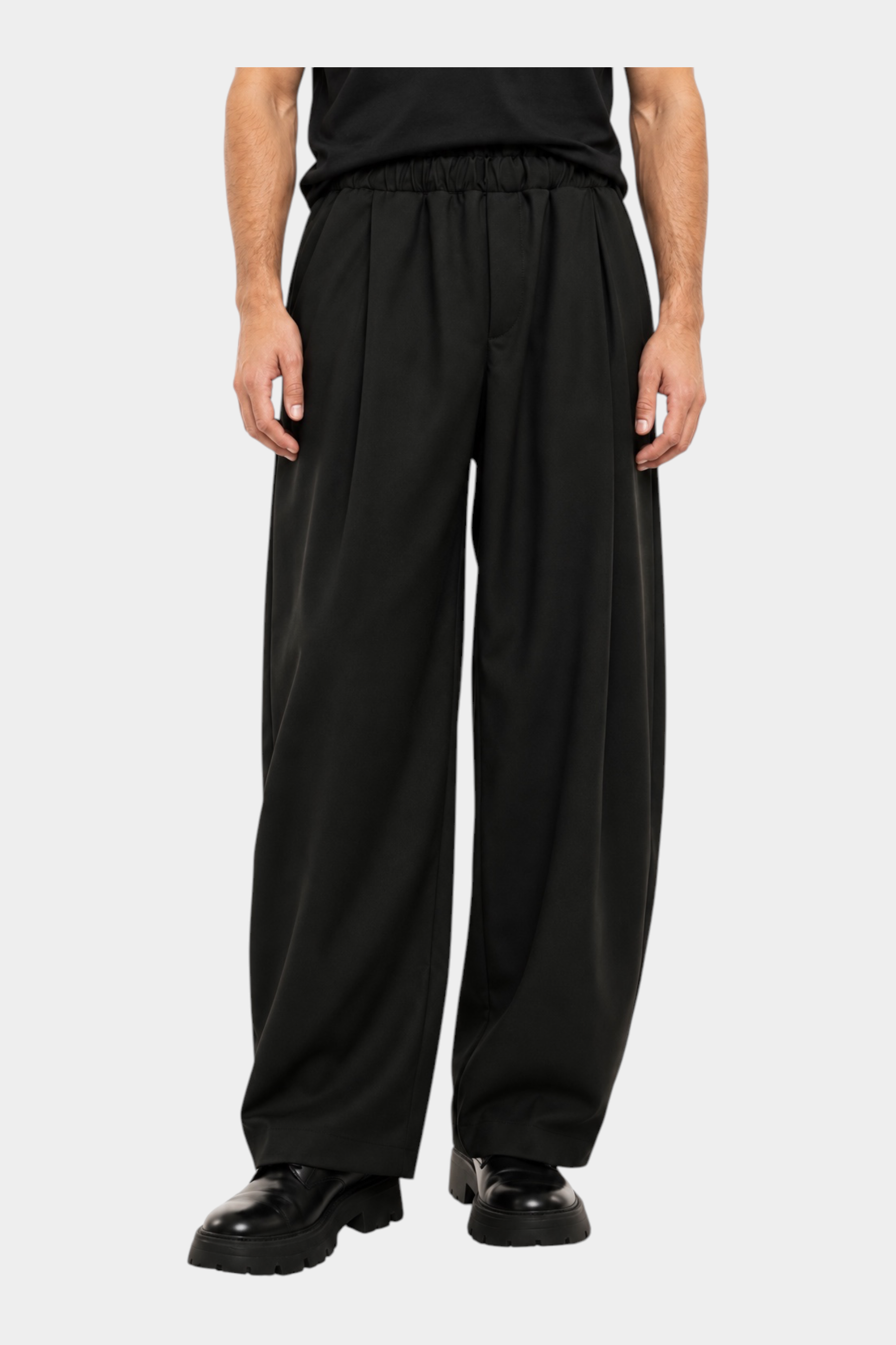 Pantaloni Follower SRL baggy-fit neri da uomo con pinces e vita elastica indossati con scarpe nere