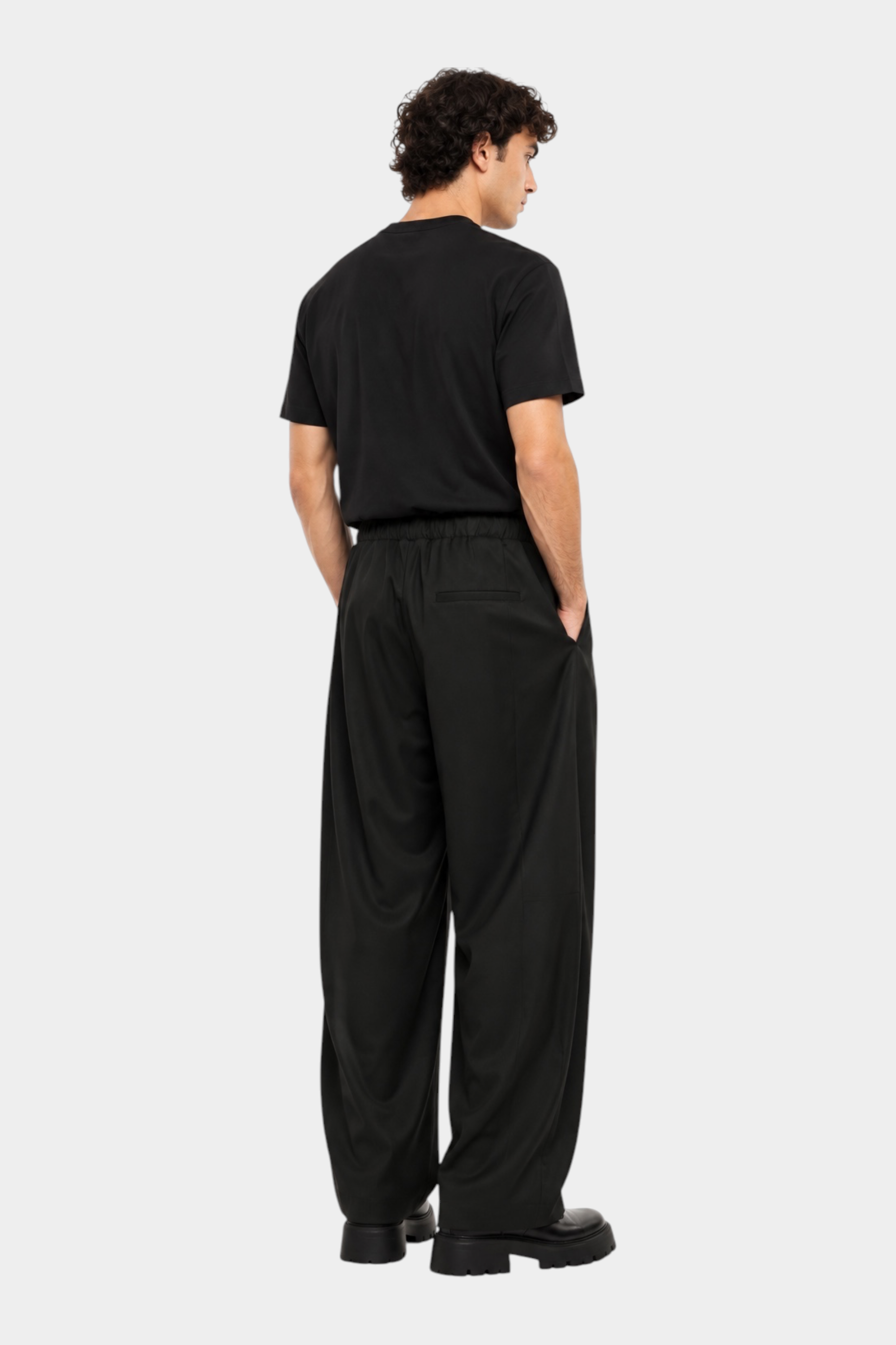 Pantaloni baggy-fit neri con pinces indossati da un modello, collezione Follower SRL, vista posteriore