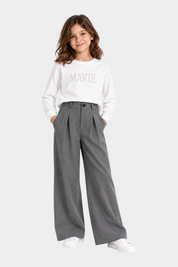Bambina indossa pantaloni Follower SRL grigi a gamba larga con pence e maglia bianca a maniche lunghe