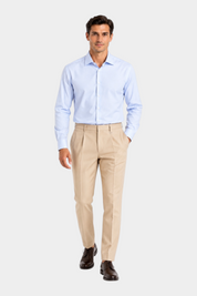 Modello indossa pantaloni regular beige con pinces Follower SRL abbinati a camicia azzurra e scarpe eleganti