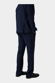 Pantaloni classici da uomo blu GUESS indossati con giacca abbinata, vista posteriore, proposti da Follower SRL