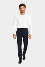Modello indossa pantaloni classici blu scuro GUESS abbinati a maglia bianca a maniche lunghe di Follower SRL