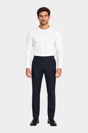 Modello indossa pantaloni classici blu scuro GUESS di Follower SRL abbinati a maglia bianca a maniche lunghe