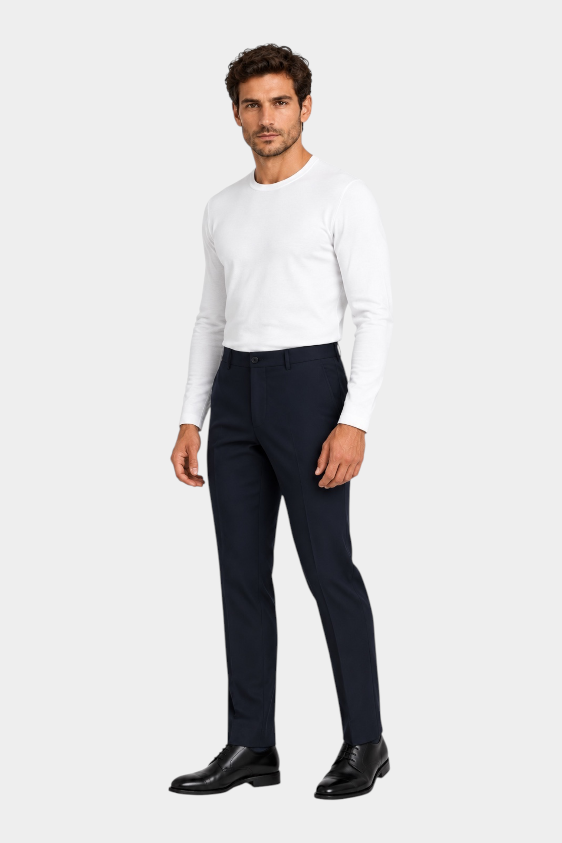 Modello indossa pantaloni classici blu scuro GUESS abbinati a maglia bianca a maniche lunghe, stile elegante