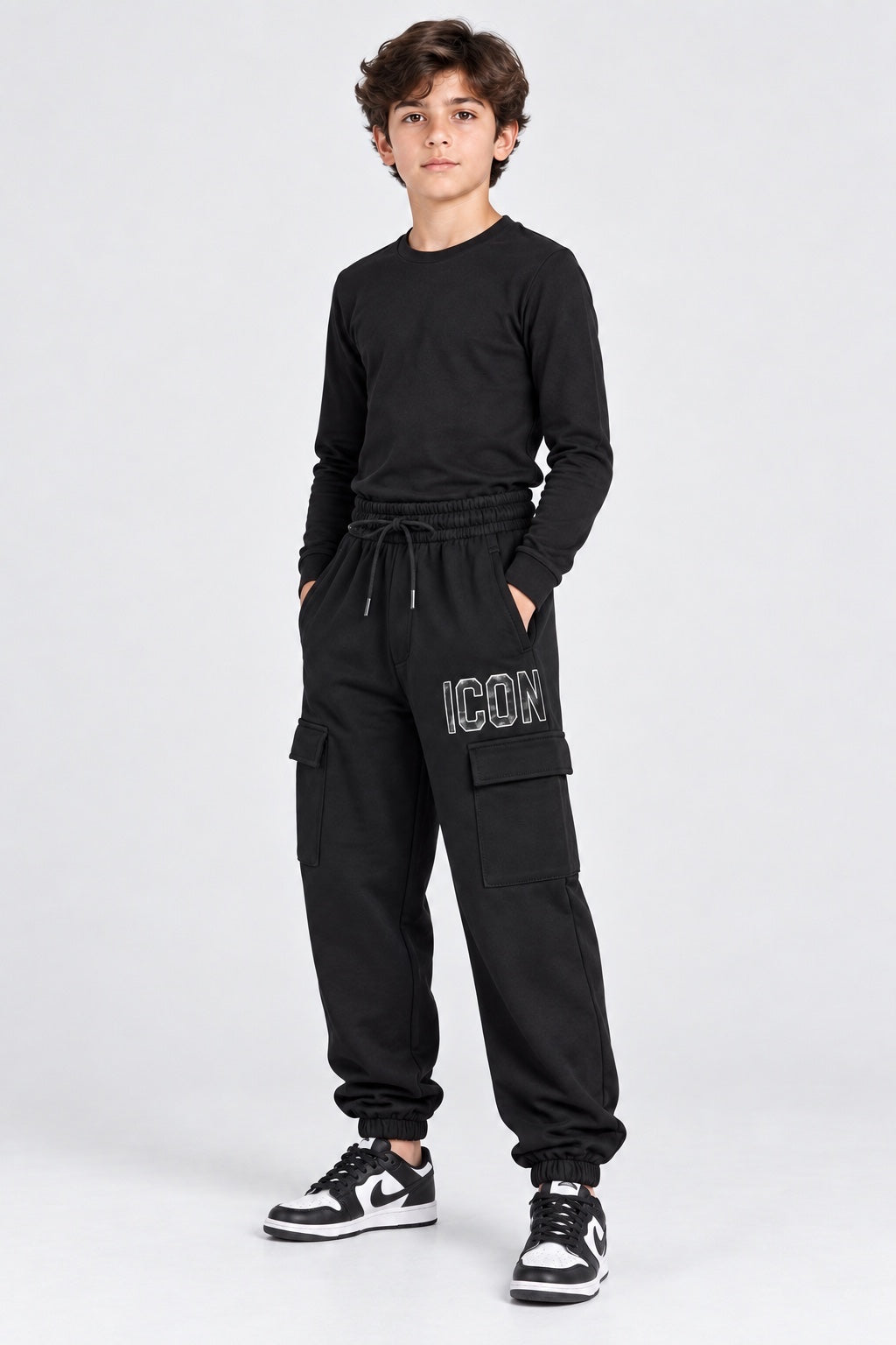 Ragazzo indossa pantaloni jogger cargo neri Follower SRL con scritta ICON bianca e tasche laterali