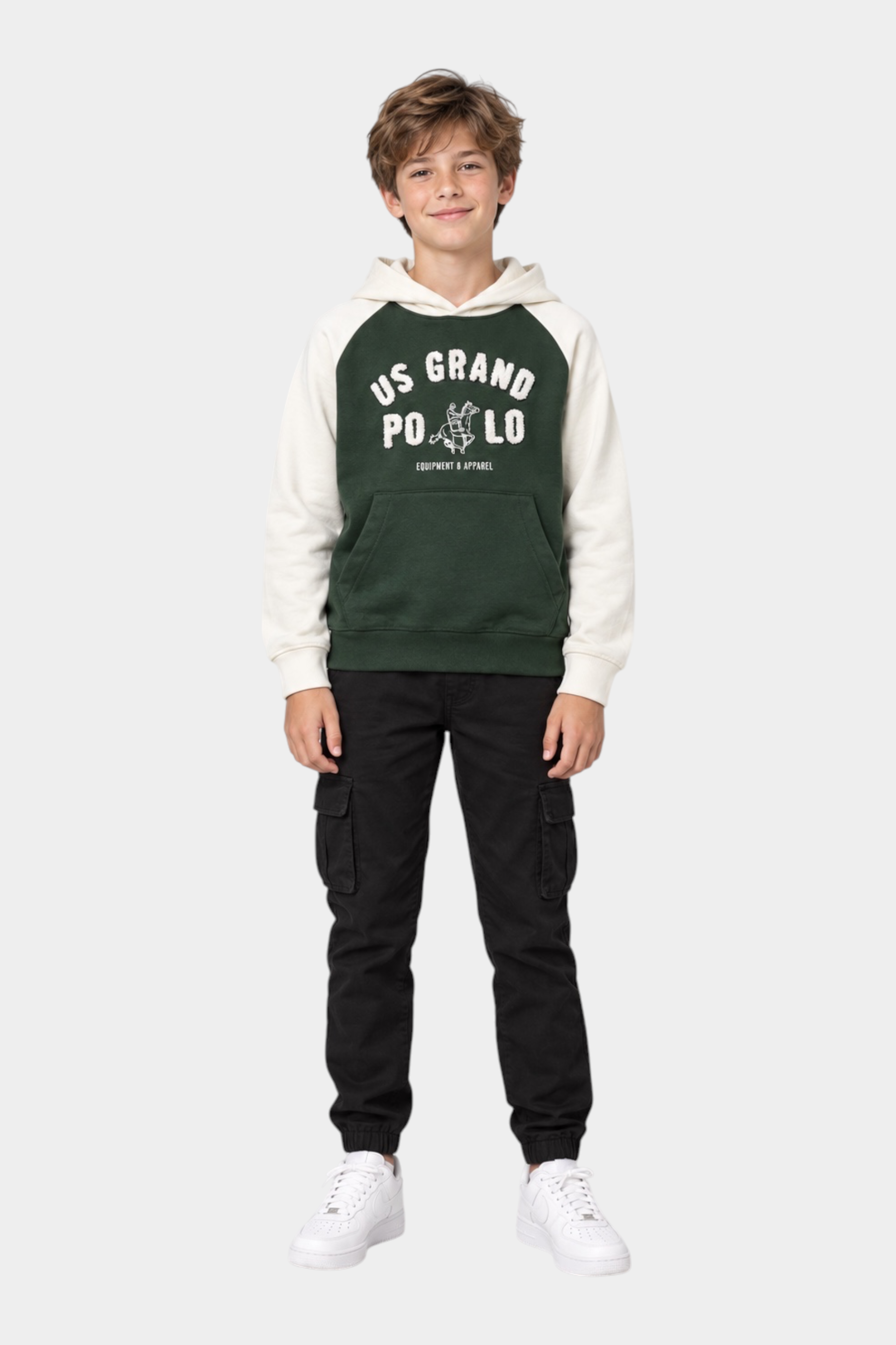 Ragazzo indossa pantaloni jogger cargo neri Follower SRL abbinati a una felpa con cappuccio verde e bianca