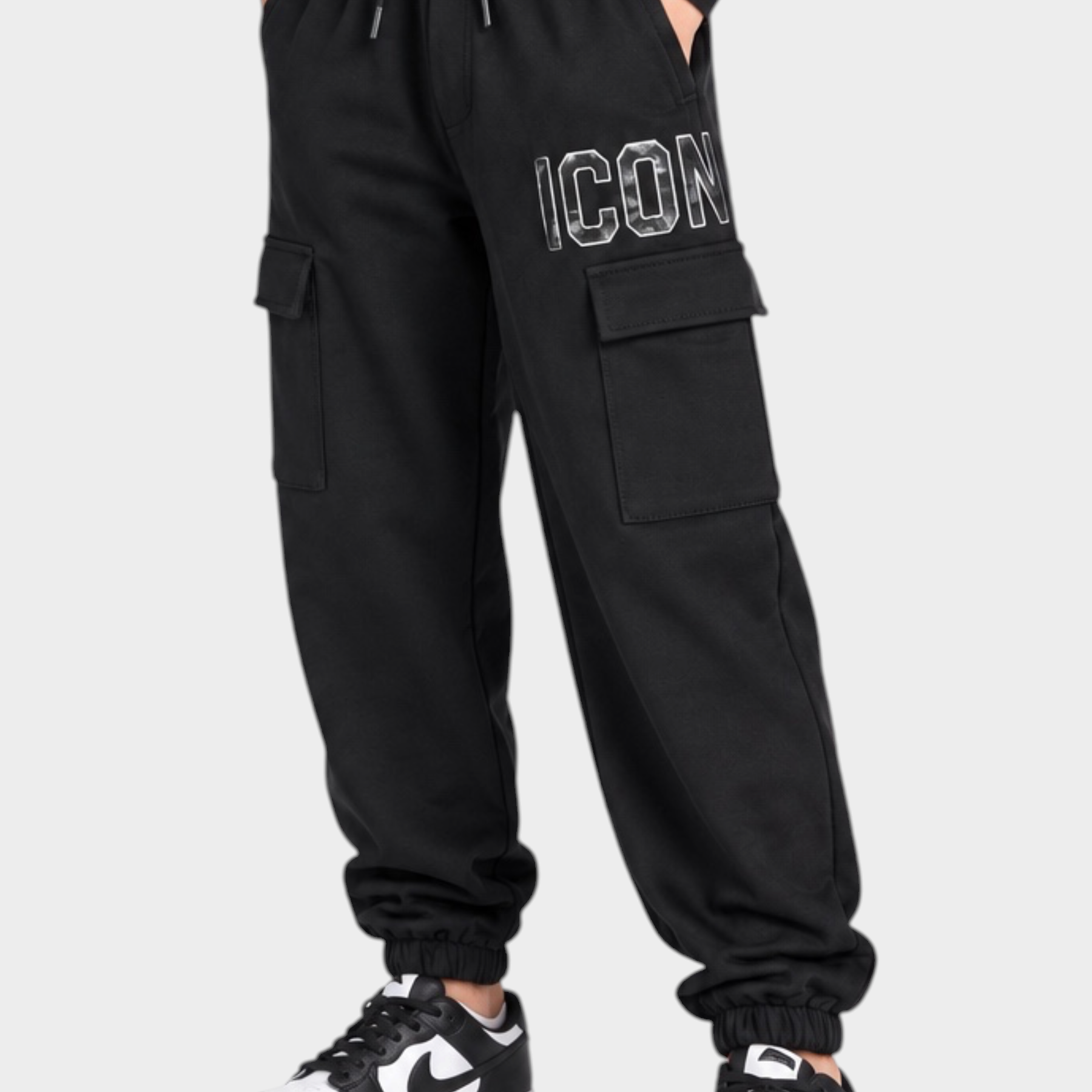 Ragazzo indossa pantaloni jogger cargo neri Follower SRL con scritta ICON e scarpe da ginnastica