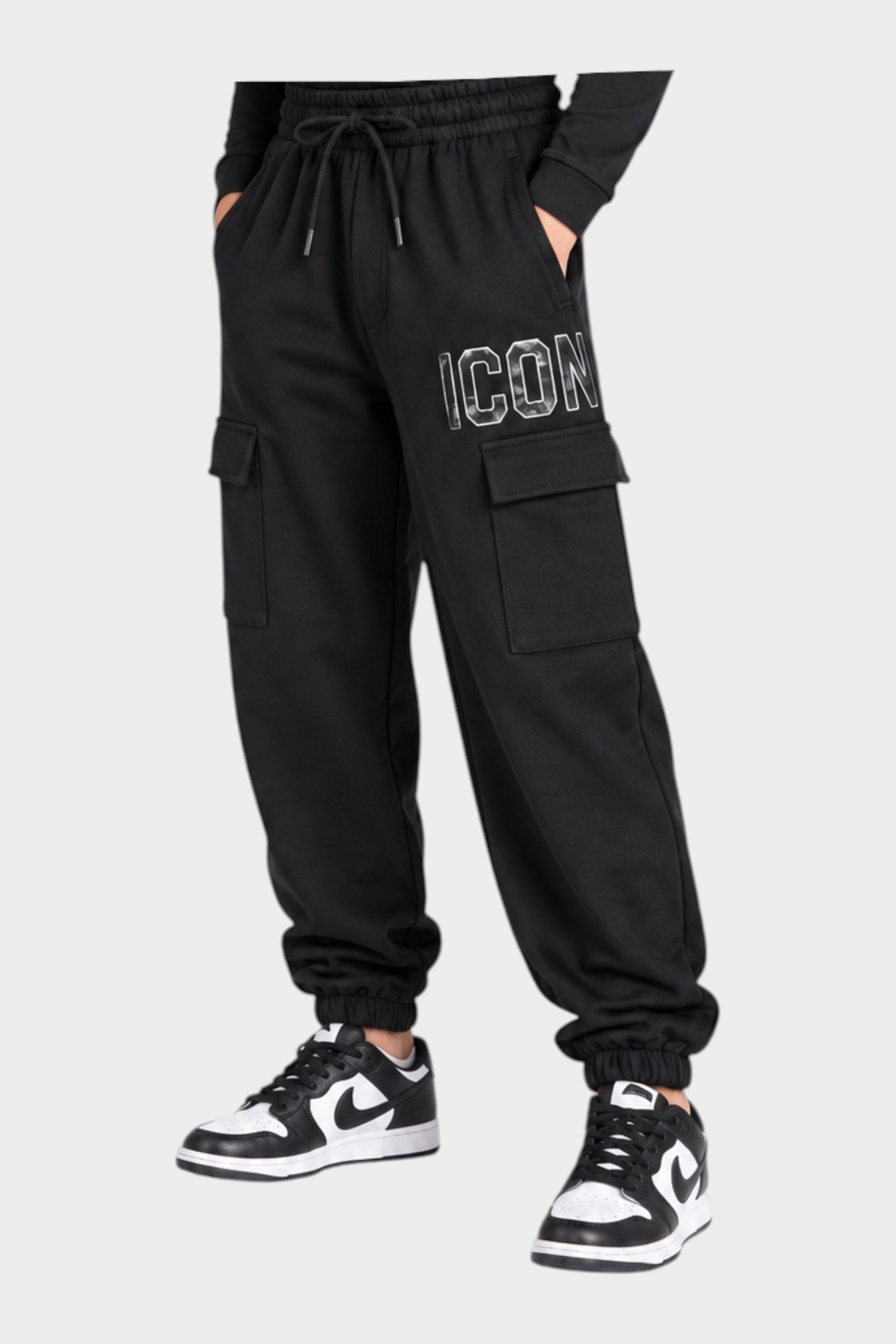 Ragazzo indossa pantaloni jogger cargo neri Follower SRL con scritta ICON e scarpe da ginnastica