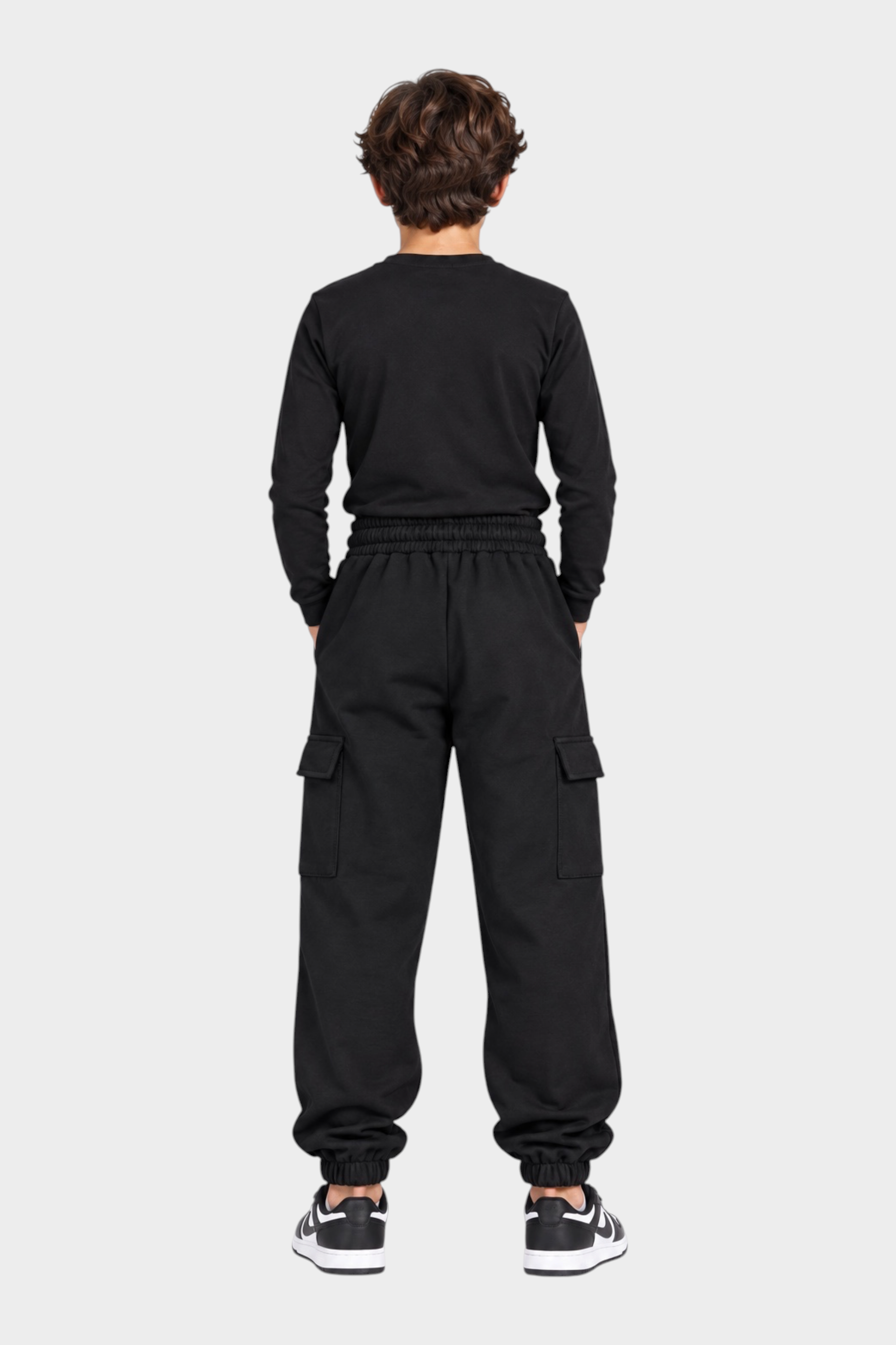 Ragazzo di spalle indossa pantaloni jogger cargo neri ICON di Follower SRL con tasche laterali e polsini elasticizzati