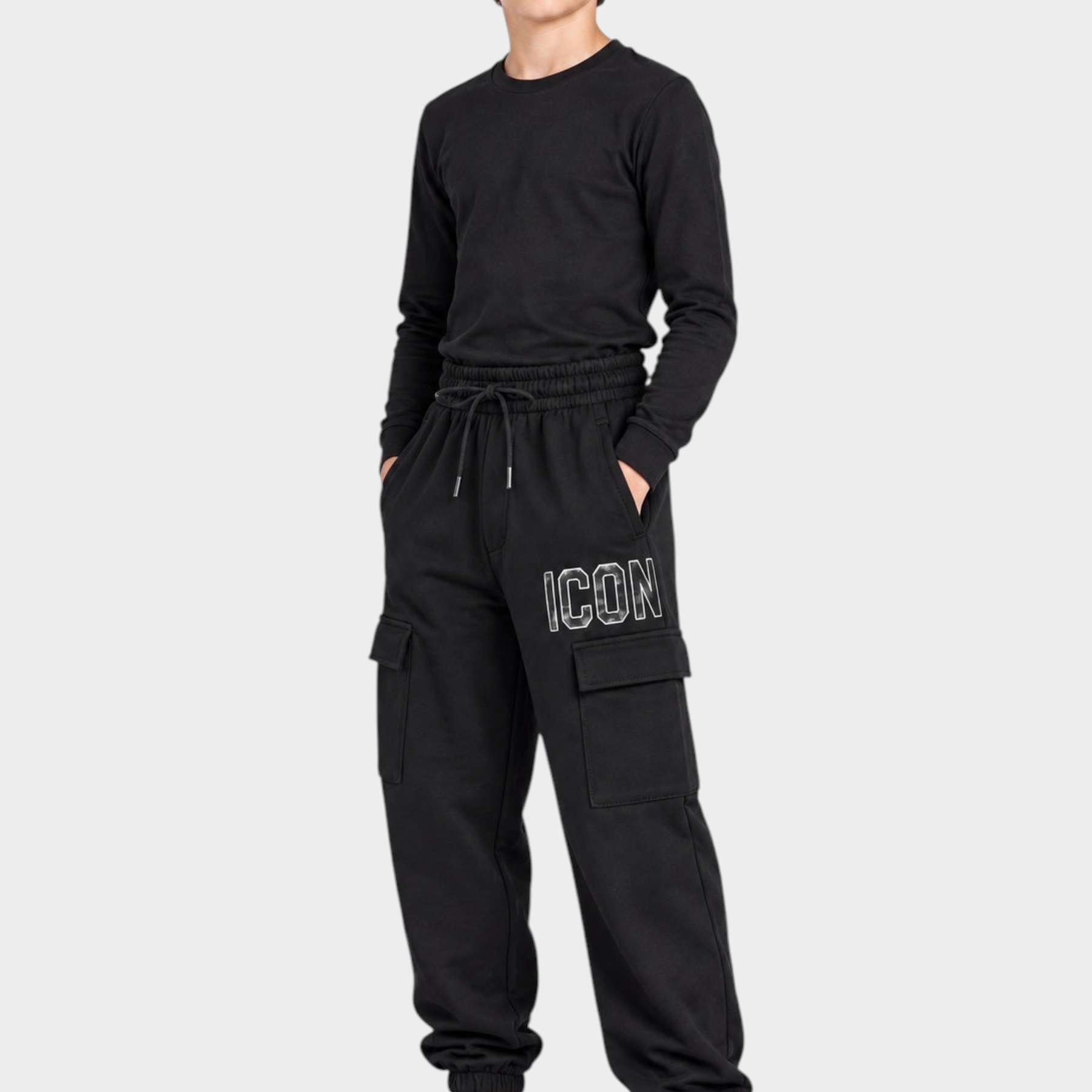 Ragazzo indossa pantaloni jogger cargo neri Follower SRL con scritta ICON bianca e tasche laterali