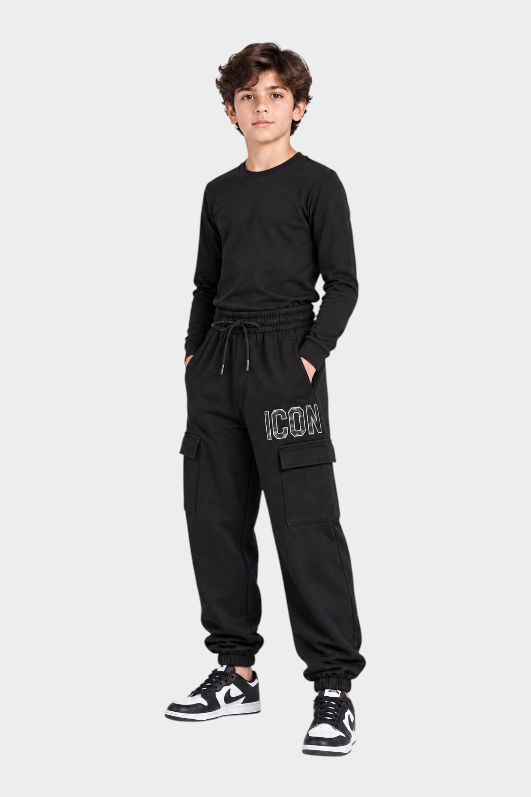 Ragazzo indossa pantaloni jogger cargo neri Follower SRL con scritta ICON bianca e tasche laterali