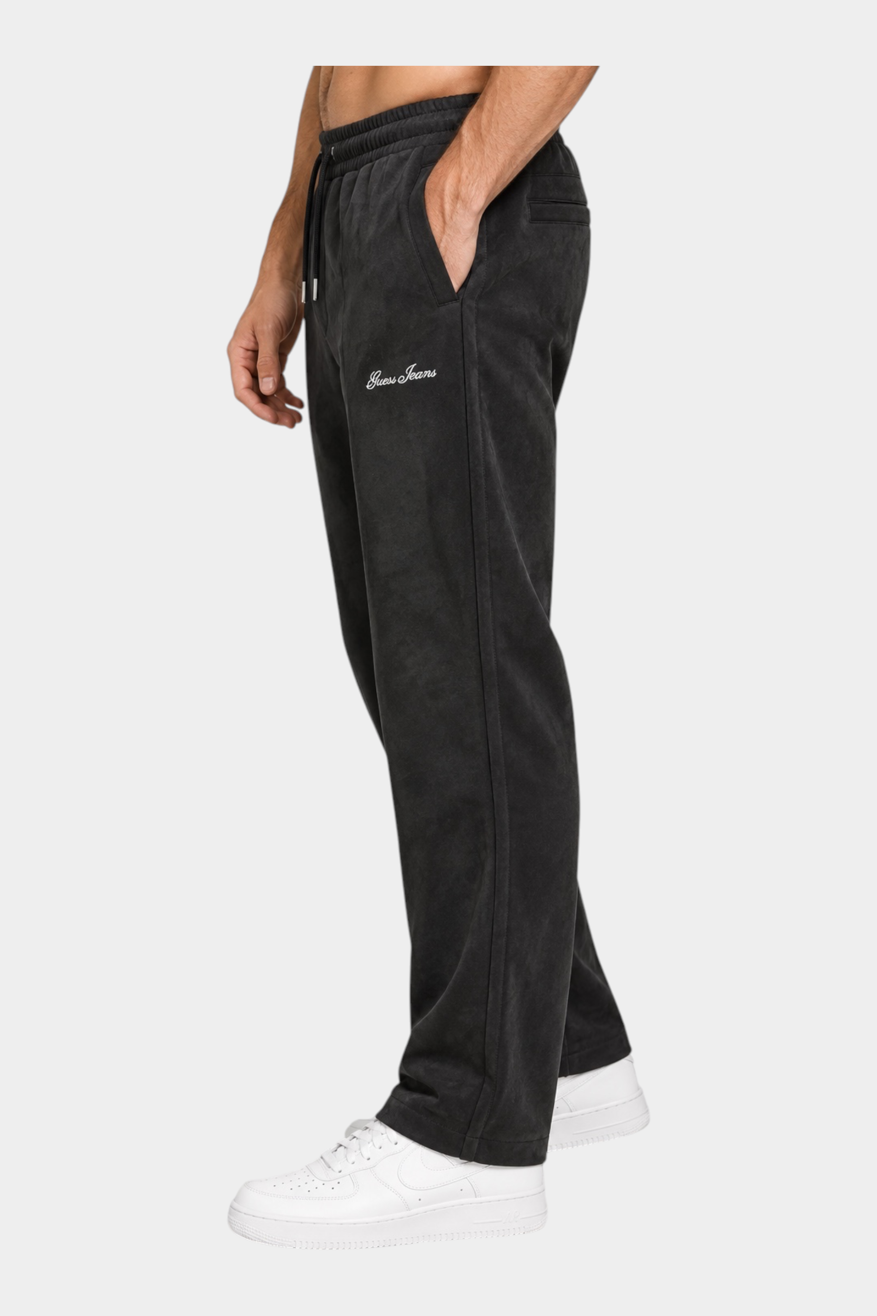 Pantaloni jogger neri in ciniglia GUESS indossati da un modello, vista laterale, collezione Follower SRL