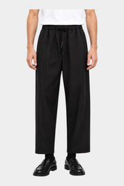 Pantaloni neri baggy-fit Follower SRL con coulisse in vita e pince frontali, indossati da un modello