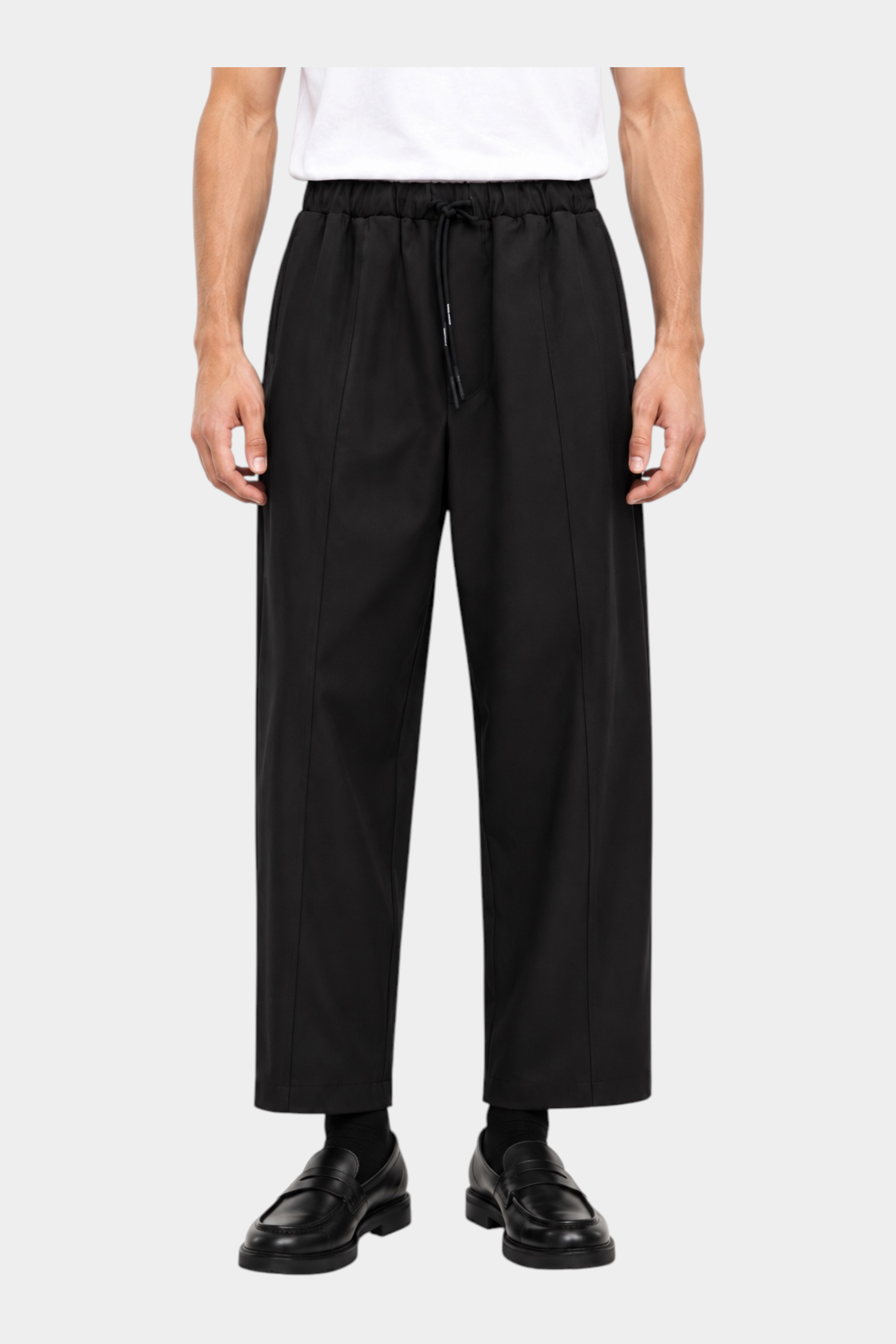 Pantaloni neri baggy-fit Follower SRL con coulisse in vita e pince frontali, indossati da un modello