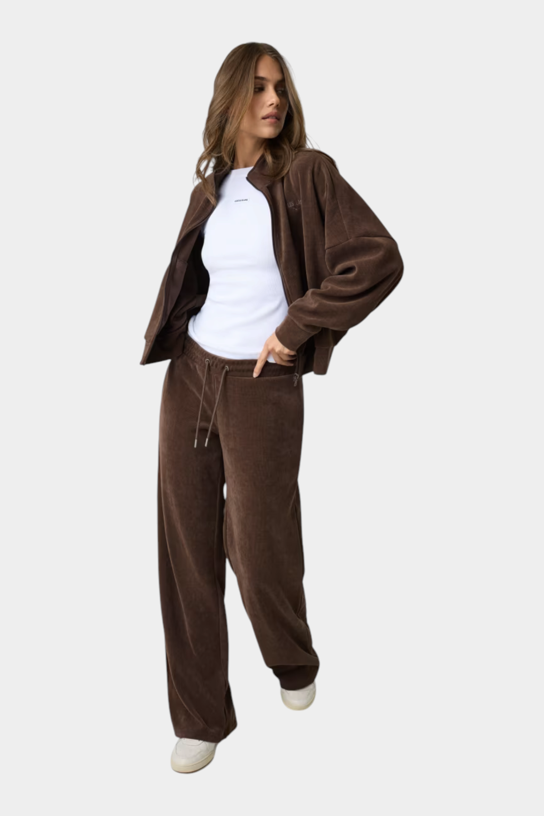 Modella indossa pantaloni della tuta a coste marroni GUESS con giacca abbinata, stile casual Follower SRL