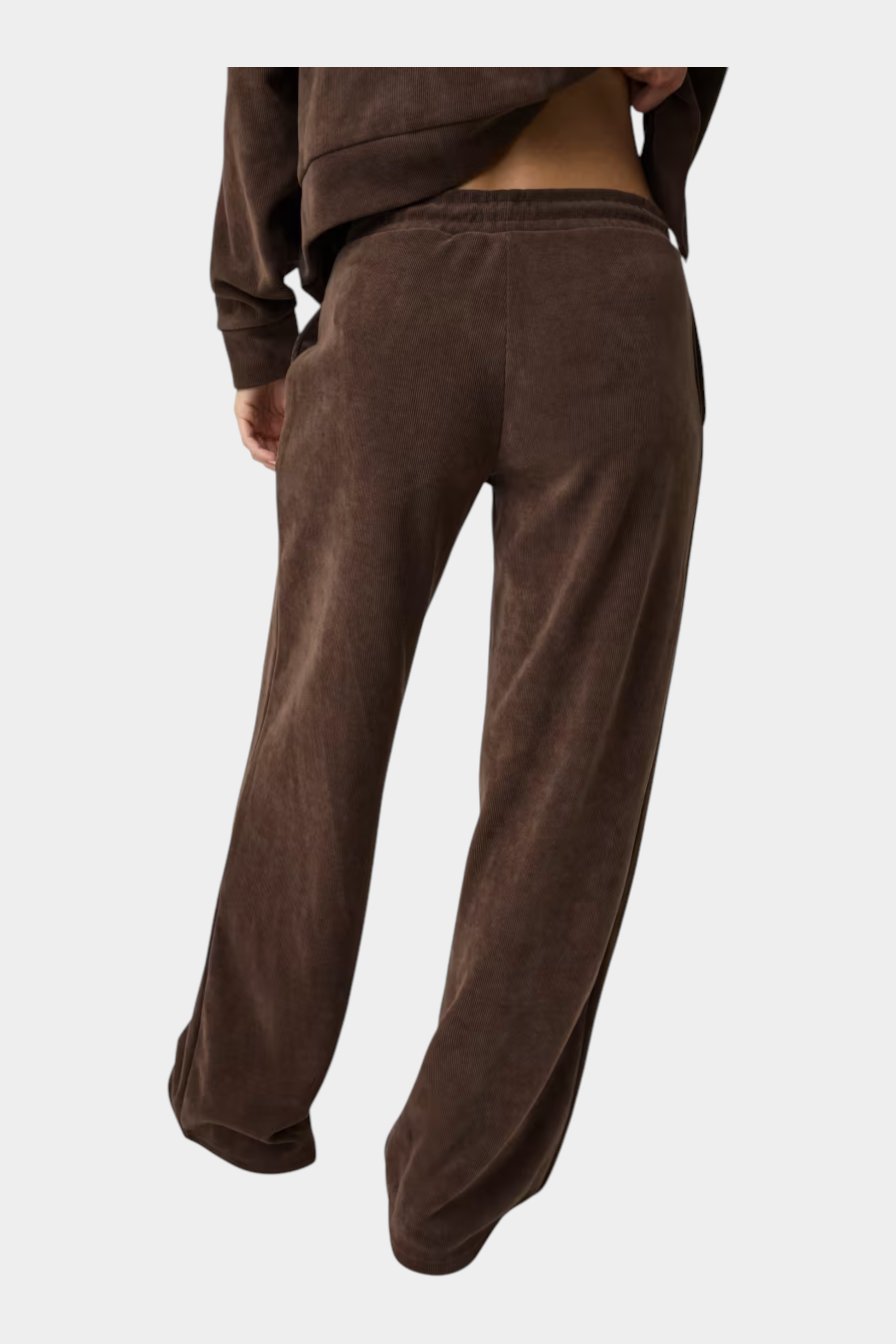 Pantaloni della tuta a coste marroni GUESS indossati da una donna, vista posteriore, stile casual e confortevole