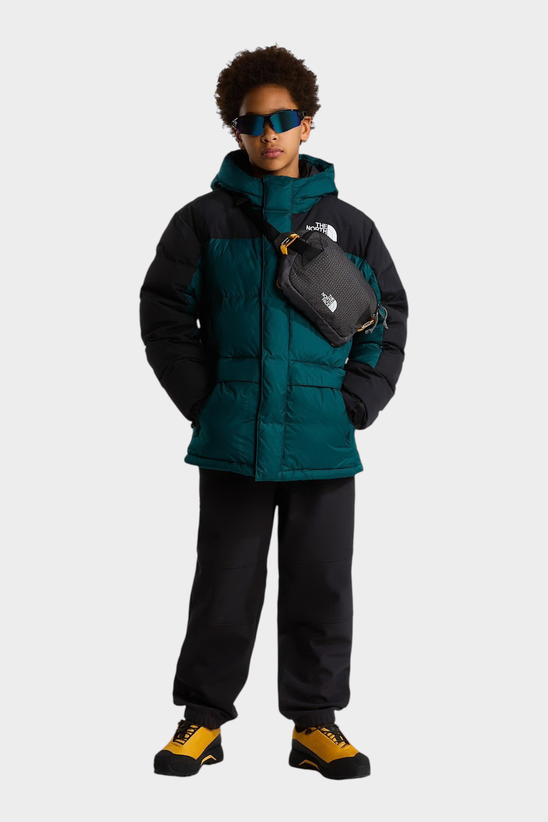 Modello indossa parka corto Follower SRL The North Face verde e nero con imbottitura in piumino e marsupio