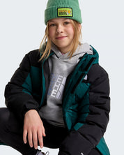 Ragazza indossa un parka corto Follower SRL The North Face verde e nero con imbottitura in piumino e berretto verde