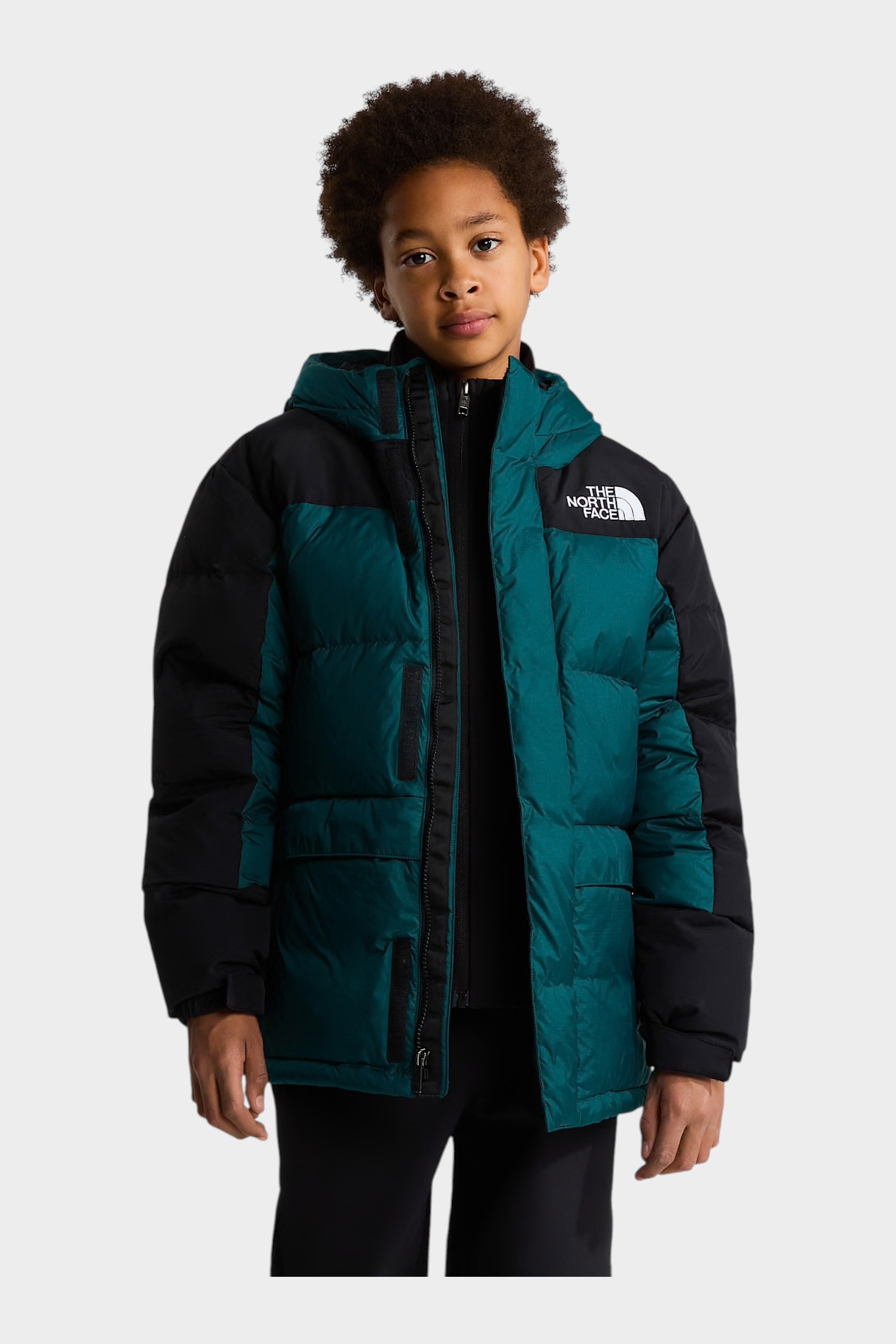 Ragazzo indossa un parka corto Follower SRL The North Face verde e nero con imbottitura in piumino 600 e cappuccio