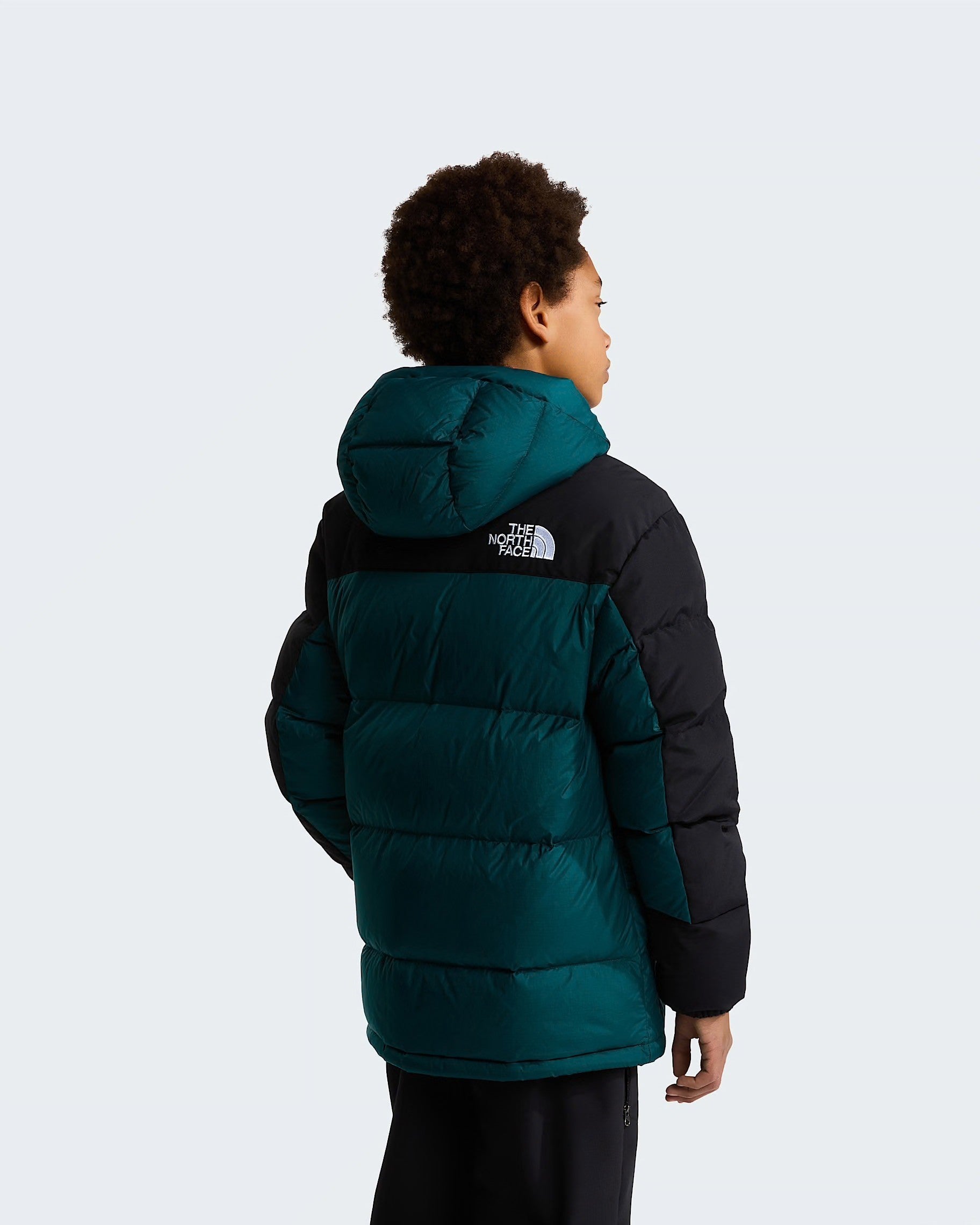 Modello indossa parka corto Follower SRL The North Face verde e nero con imbottitura in piumino e cappuccio