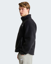 Modello indossa pile nero THE NORTH FACE Fleeski con cerniera a 1/4, vista laterale su sfondo neutro Follower SRL