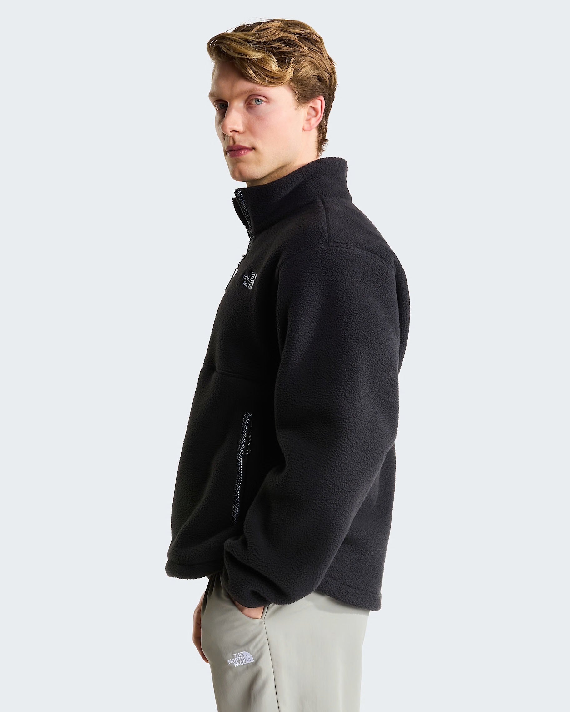 Modello indossa pile nero THE NORTH FACE Fleeski con cerniera a 1/4, vista laterale su sfondo neutro Follower SRL