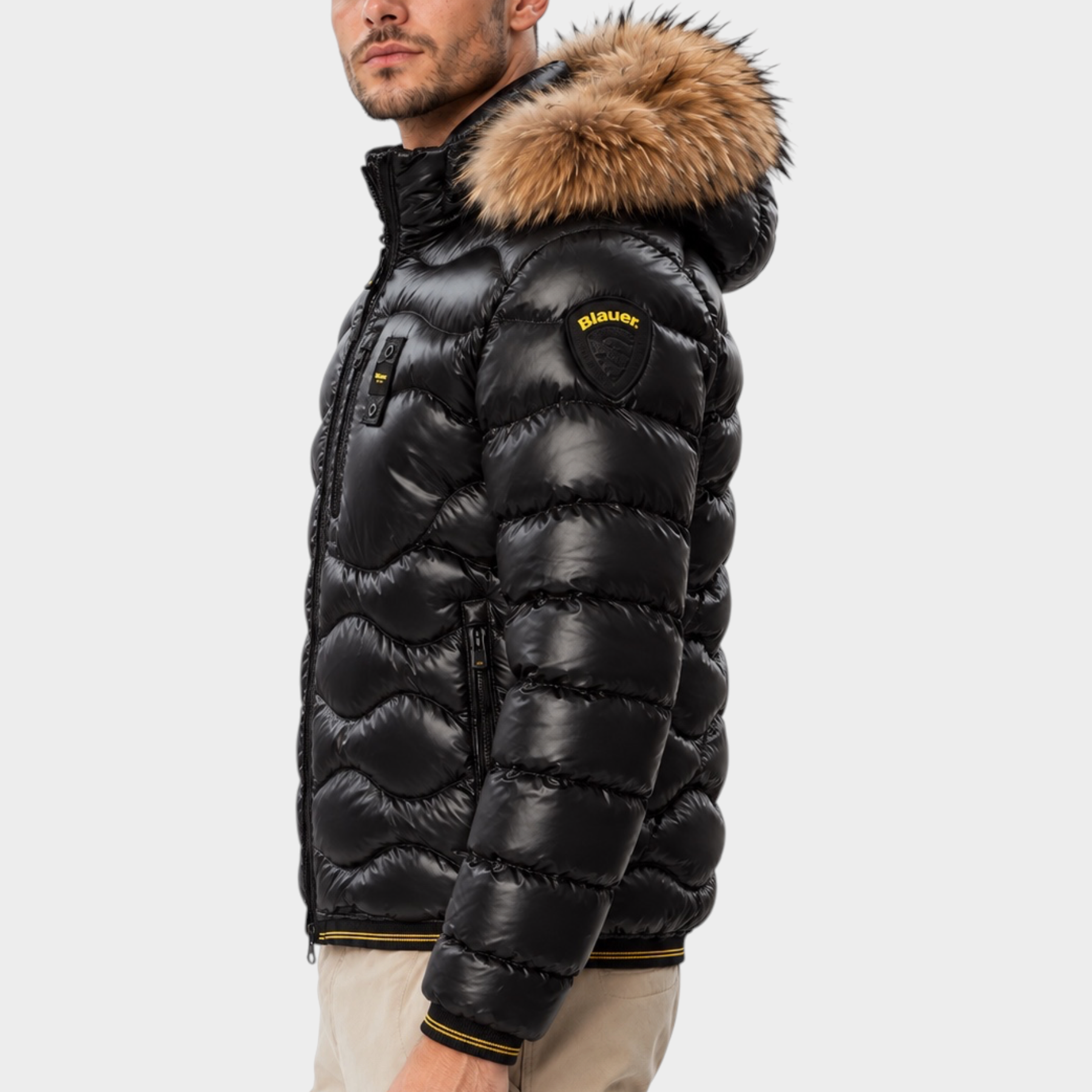 Modello indossa piumino nero trapuntato a onde Follower SRL con cappuccio in pelliccia e logo Blauer sulla manica