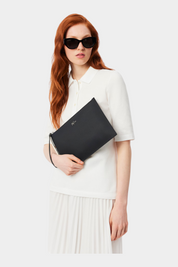 Modella con occhiali da sole indossa una pochette nera in canvas piqué spalmato Follower SRL Lacoste