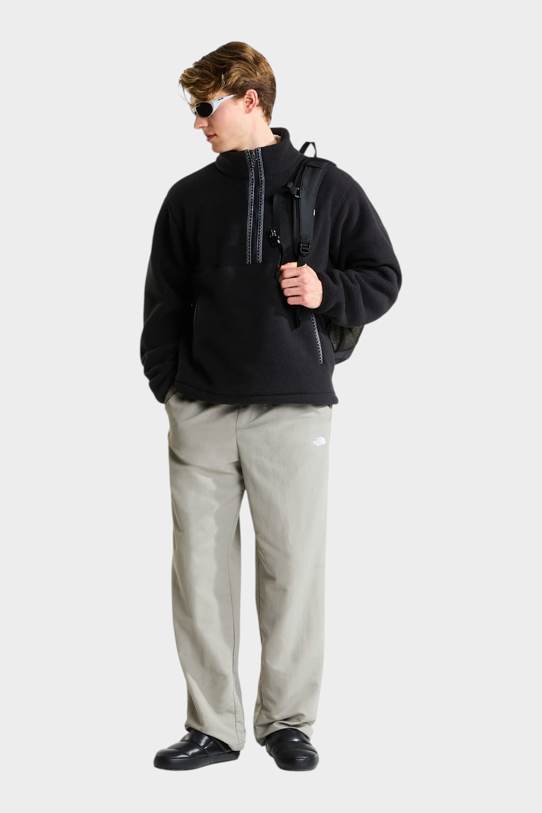 Modello Follower SRL indossa pullover in pile nero THE NORTH FACE con cerniera a 1/4 e zaino, stile casual urbano