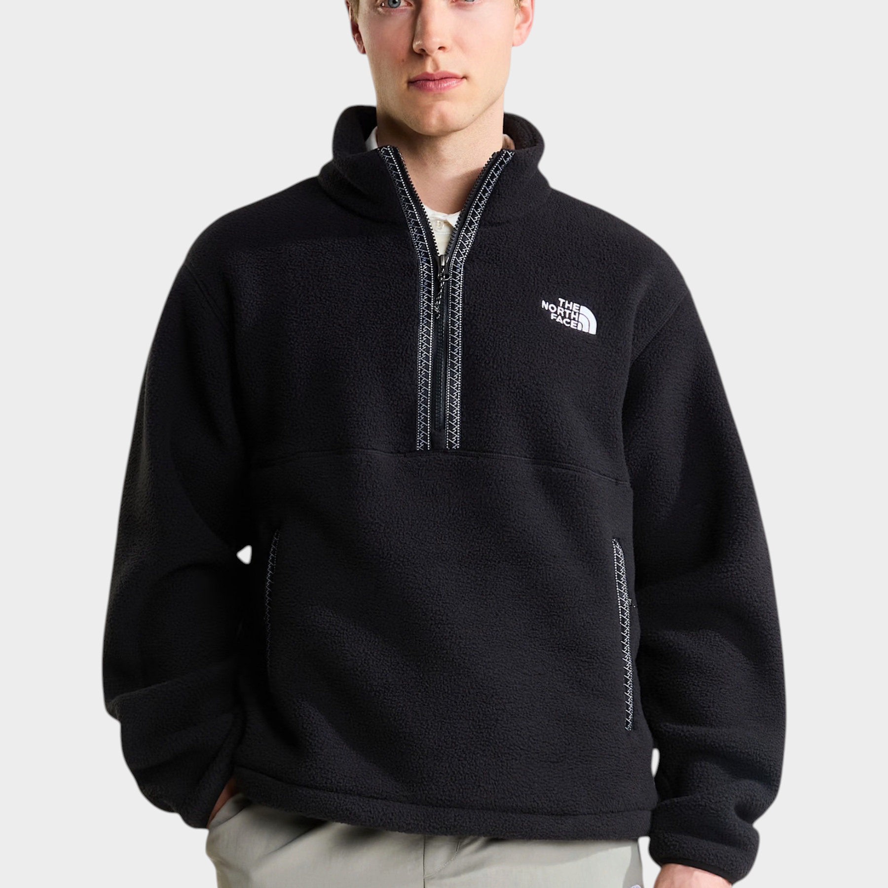 Modello indossa un pullover in pile nero Follower SRL con cerniera a un quarto e logo The North Face sul petto
