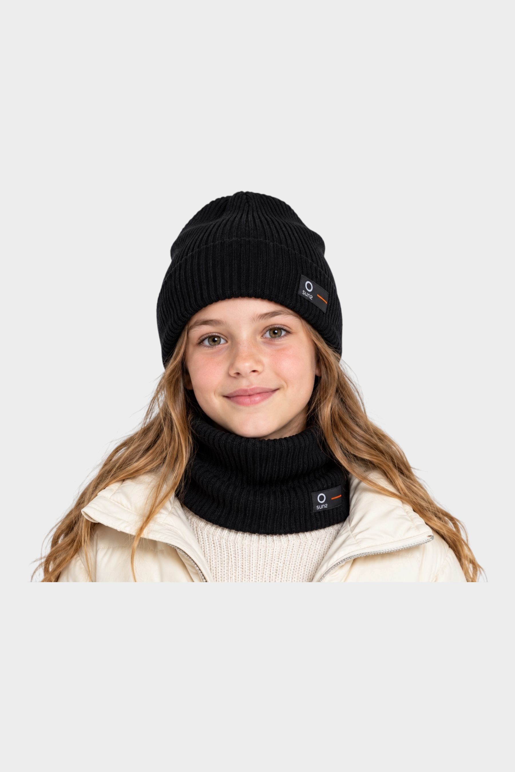 Ragazza indossa scaldacollo e berretto neri in cotone a coste Follower SRL con logo SUNS BOARDS