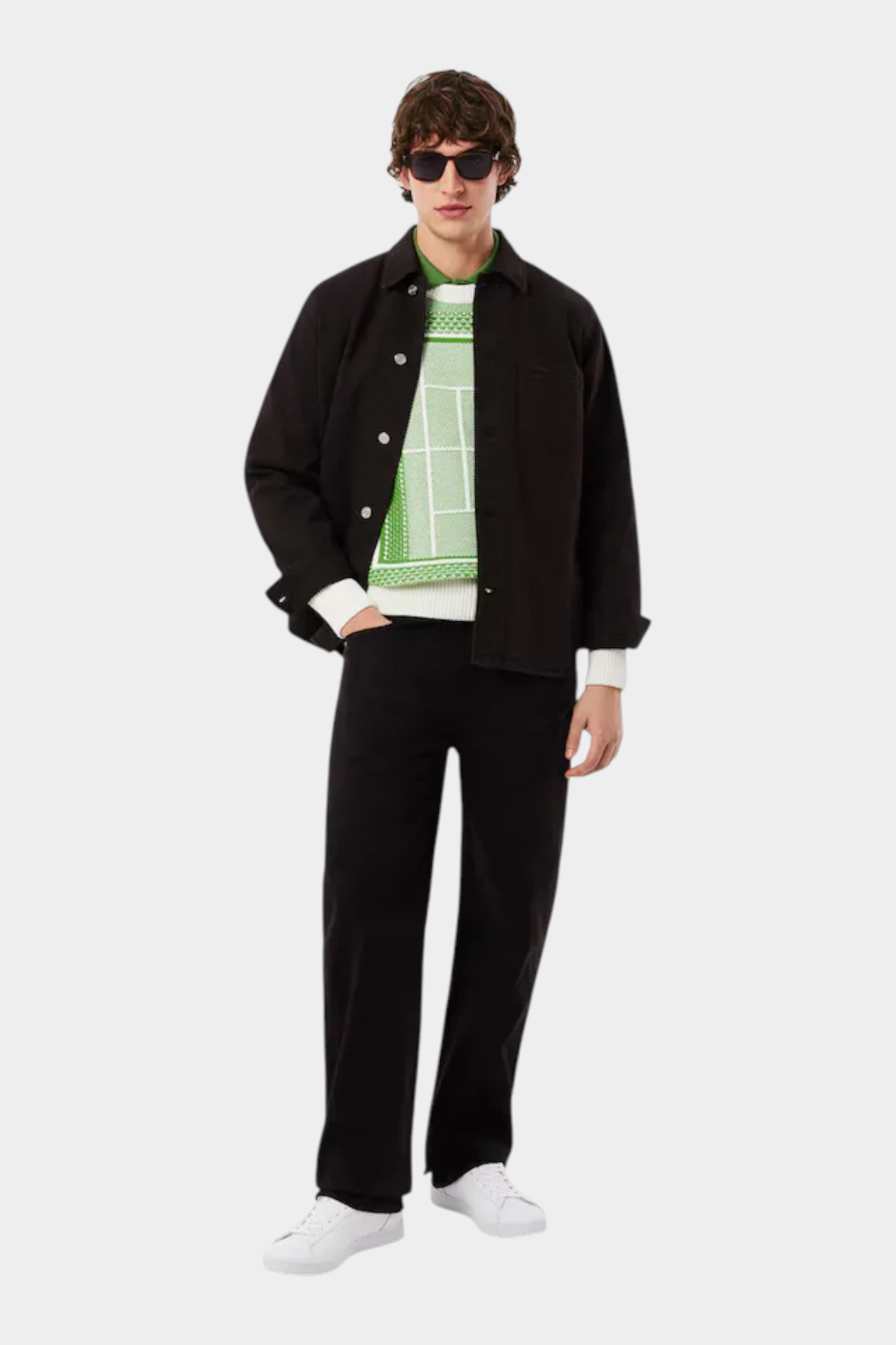 Modello Follower SRL indossa sneakers bianche in pelle LACOSTE Carnaby con giacca nera e maglione verde